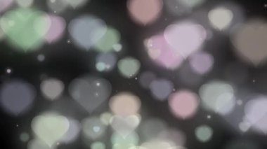 Soyut hareket arka planı parlayan kalp parçacıkları. Şeffaf bokeh. Kusursuz 4K döngü video animasyonu. Açık pembe parıltılı ışıklar, çözülmüş ışık yansımaları döngüye girebilir bokeh arkaplan.