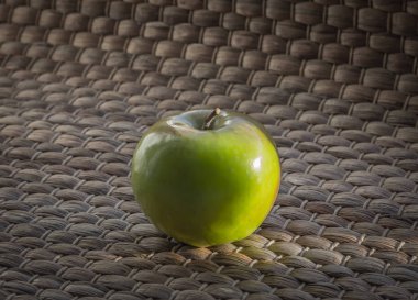 Hasır zemin üzerine yeşil elma.