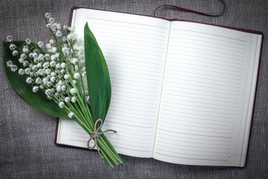 Açık boş günlüğü bir paspas arka planda Vadideki Zambak bir buket. Vintage sesi. Romantik ruh hali.