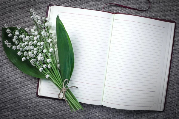 Açık boş günlüğü bir paspas arka planda Vadideki Zambak bir buket. Vintage sesi. Romantik ruh hali.