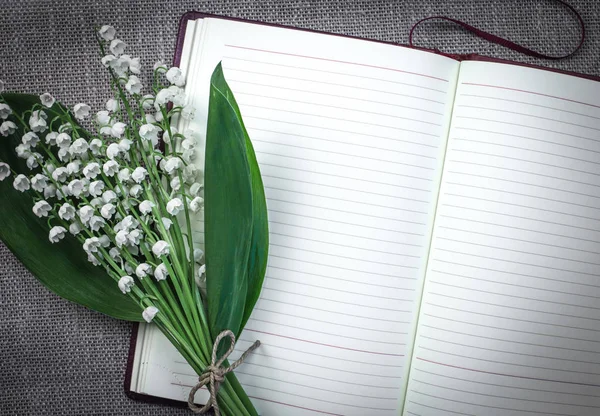 Açık boş günlüğü bir paspas arka planda Vadideki Zambak bir buket. Vintage sesi. Romantik ruh hali.