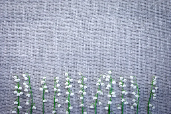 Top view of the lilies of the valley on a gray matting background. Lilies of the valley with a copy of space.