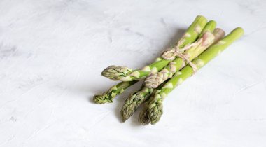 Hafif bir arka planda bir sürü yeşil kuşkonmaz var.