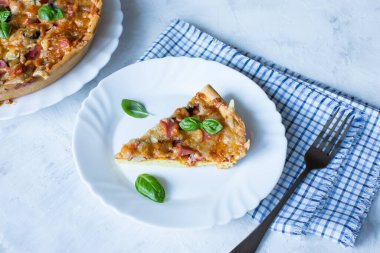 Hafif arka planda zeytin ve sosisli lezzetli ve çıtır bir pizza dilimi..