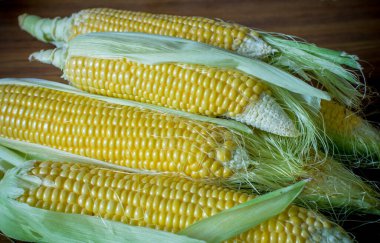 Tahta bir masada olgunlaşmış mısır, yakın plan.