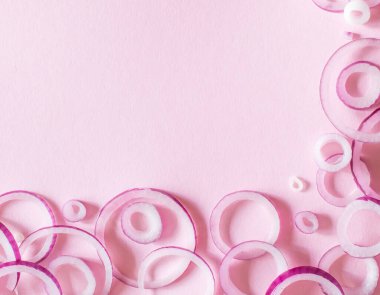 Pembe arka planda kırmızı soğan halkalarıyla dekoratif düzen, düz çizgi.