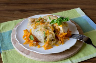 Beyaz tabakta içi doldurulmuş lahana yaprakları, yakın plan.