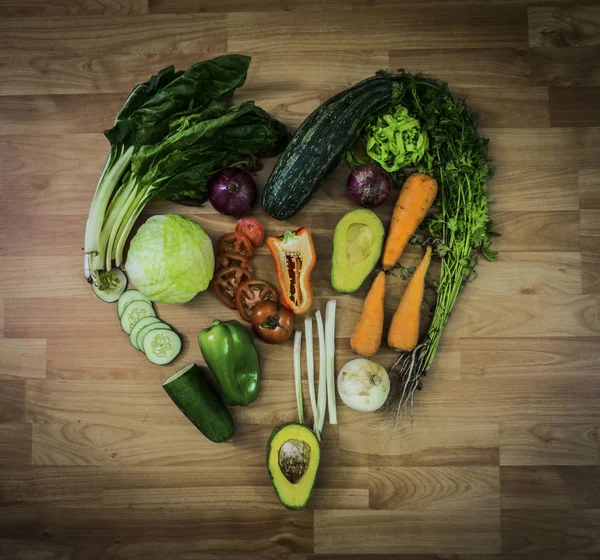 Heart symbol with vegetables on wood table