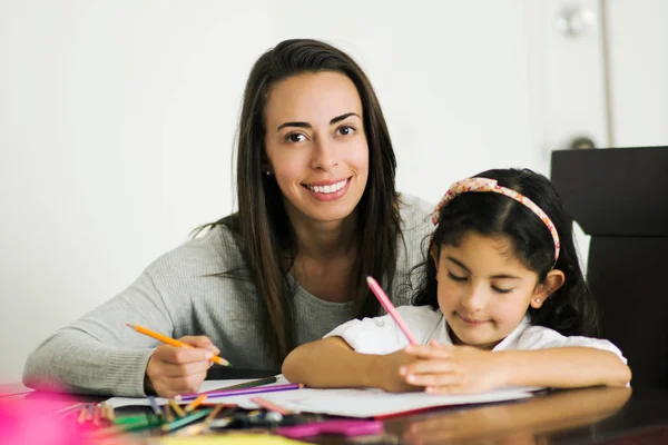 Young mom and daughter doing schoolworks together
