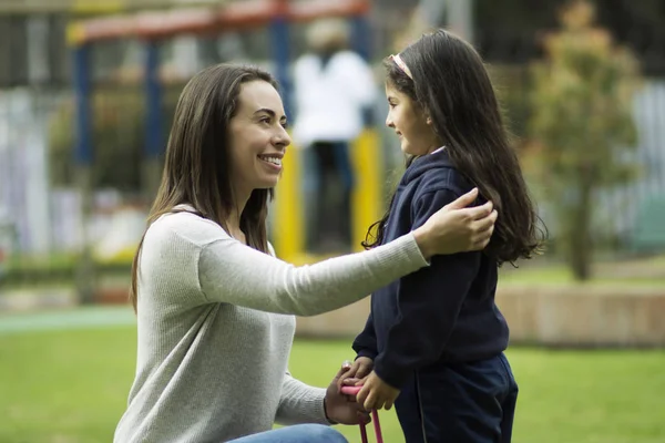 Young mom talking with her daughter before the school