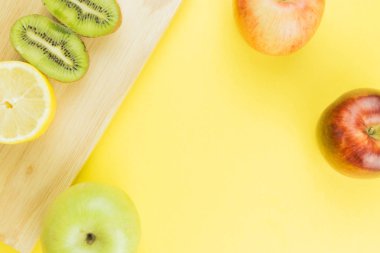 Limon ve kivi ahşap masa üzerinde ikiye böldüm. elma tarafında. Metin için sarı boş alan