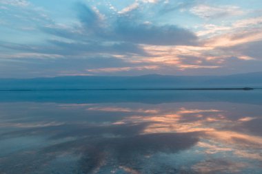 Ölü denizin üzerinde gün doğumu, suda güzel yansımalar.