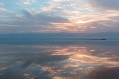 Ölü denizin üzerinde gün doğumu, suda güzel yansımalar.
