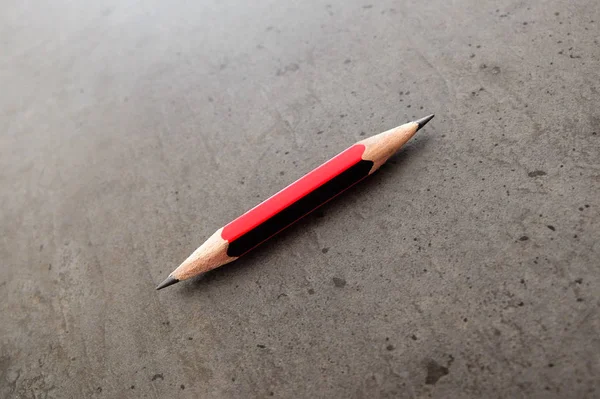 Ένα μικρό μολύβι, shapened στα δύο άκρα, σε ένα τραπέζι γκρι — Φωτογραφία Αρχείου