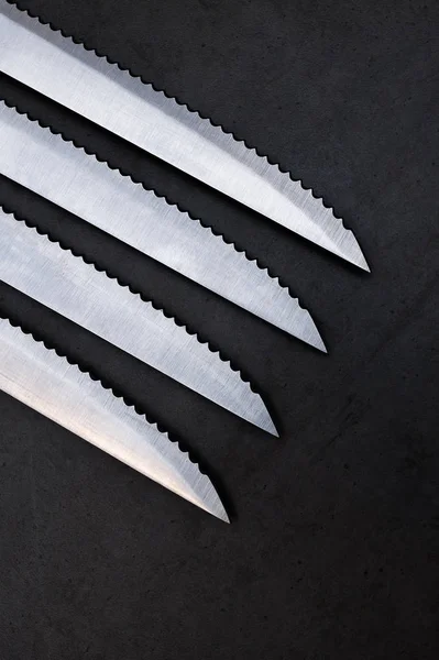 Cuchillos dentados sobre una mesa gris oscura — Foto de Stock