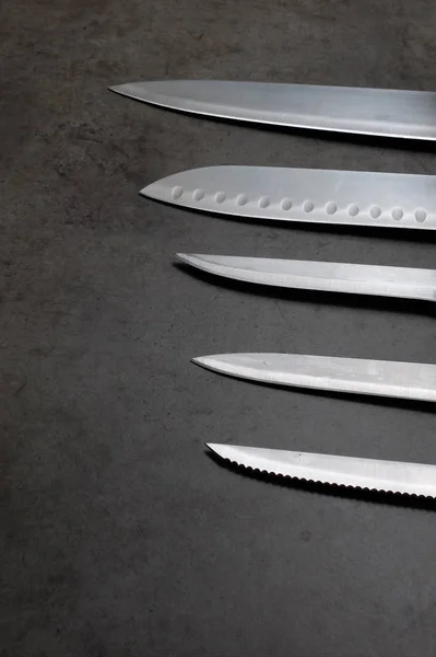 Набір ножів на темно-сірому столі — стокове фото