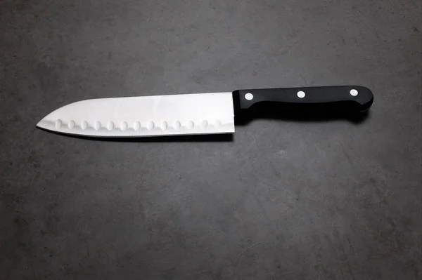 Нож шеф-повара на тёмно-сером столе — стоковое фото