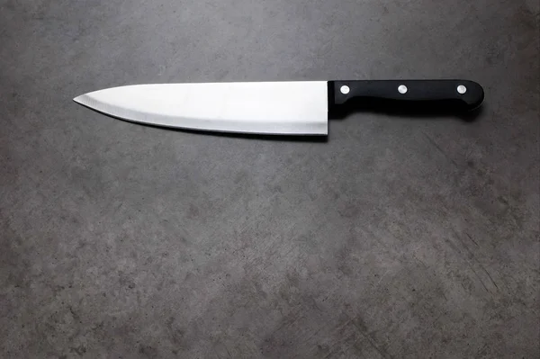 Cuchillo de chef sobre una mesa gris oscura — Foto de Stock