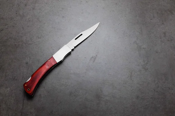 Coltello da tasca pieghevole su un tavolo grigio scuro — Foto Stock