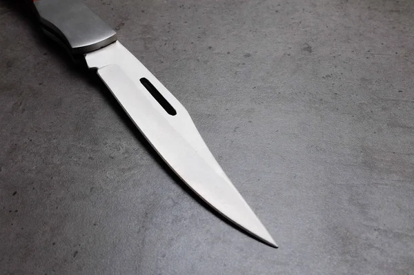 Coltello da tasca pieghevole su un tavolo grigio scuro — Foto Stock