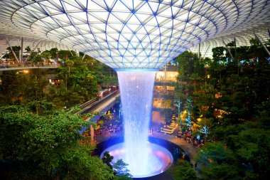 Singapur ağaçları ve Changi havaalanındaki en uzun kapalı şelale. İkinci katta, şelalenin önünde yüksek hızlı tren var..