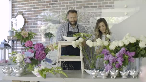Proprietari di piccola impresa di negozio per fiori che dispongono mazzo di rose bianche — Video Stock