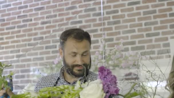 Detailní záběr úsměvem květinářství kolegy pracující v květinářství — Stock video