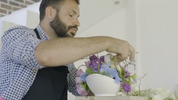 Бородатий красивий флорист готує квіти для заходу в магазині флористів — стокове відео