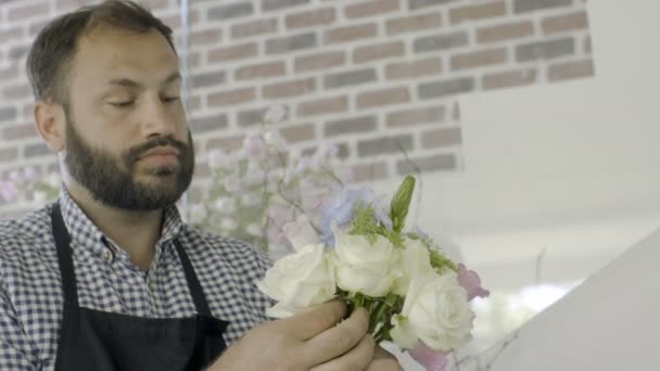 Florist man gör en bukett vackra blommor på blomsteraffär — Stockvideo