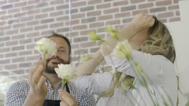 Un couple de fleuristes s'amusent et rient heureux au magasin de fleurs . — Video