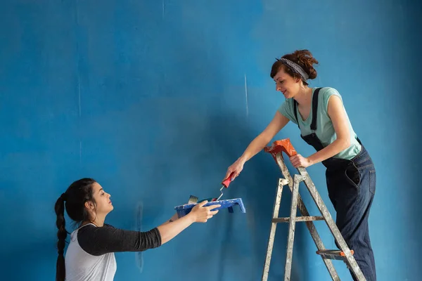 Hezké dívky Malování modré zdi Stock Snímky