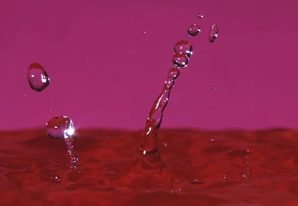 splash resulting from the impact of a drop with a container filled with water, freezing a fraction of a second