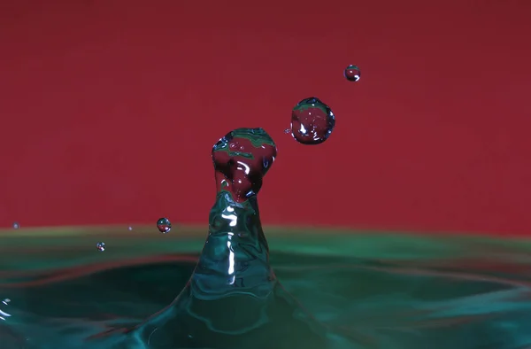 splash resulting from the impact of a drop with a container filled with water, freezing a fraction of a second