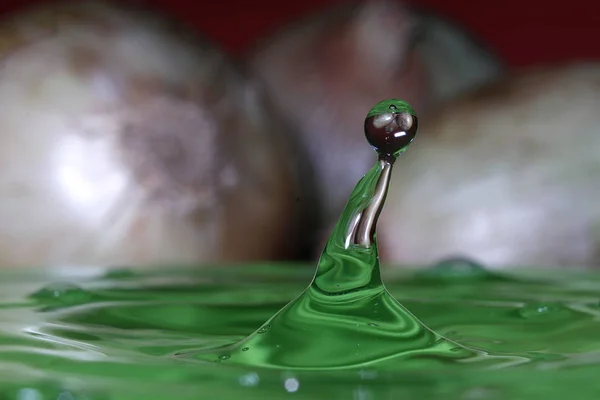 splash resulting from the impact of a drop with a container filled with water, freezing a fraction of a second