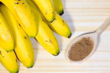 ahşap masa üzerinde muz, tarçın tahta kaşıkla closeup demet