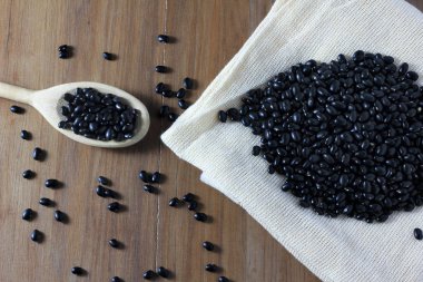 tahıl fasulye çanta ahşap masa, siyah fasulye, üstten görünüm tahta kaşıkla tarafında siyah