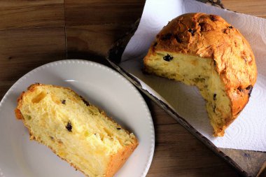 ahşap masa, dilim beyaz tabakta, üstten görünüm kutusunda içinde closeup panettone