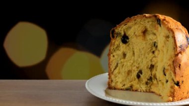 Ahşap masa, ışıkları yanıp sönen arka plan üzerinde panettone yakın çekim