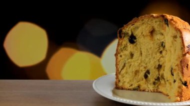 Ahşap masa, ışıkları yanıp sönen arka plan üzerinde panettone yakın çekim