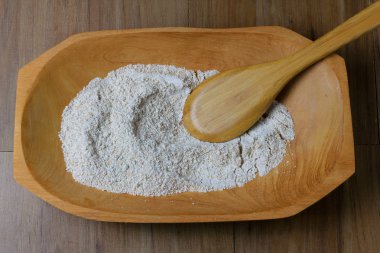 ham tam buğday unu, ahşap kase, ahşap masa, üstten görünüm bölümü