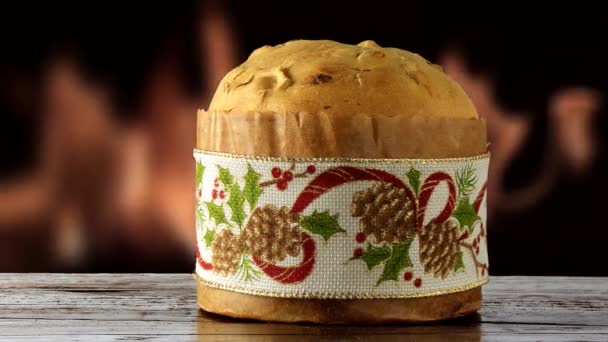 Panétone sur table en bois, se déplaçant horizontalement, décoration de Noël, feu en arrière-plan 
