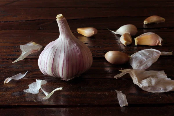 Garlic bulbs spread on rustic wooden table. Closeup of garlic bulbs.