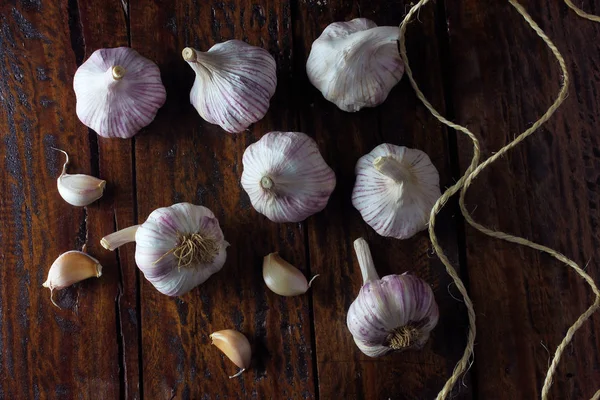 Garlic bulbs spread on rustic wooden table. Closeup of garlic bulbs. Top view