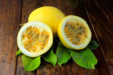 sarı tutku meyve yaprak ve tutku meyve ahşap masa üzerinde ikiye böldüm. Yakın çekim