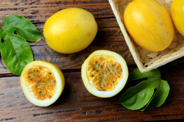 sarı tutku meyve sepeti ve tutku meyve içinde yaprak ile ahşap masa üzerinde ikiye böldüm. Üstten görünüm