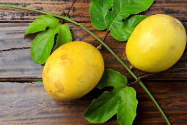 dallar ve ahşap masa üzerinde izole sarı tutku meyve ile bırakır. Üstten görünüm portre