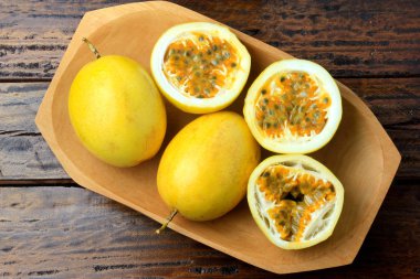 sarı tutku meyve ve tutku meyve ahşap masa üzerinde ahşap kase ikiye böldüm. Üstten görünüm