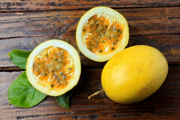 Gele Passievrucht Met Bladeren Passievruchten Snij Doormidden Geïsoleerd Houten Tafel — Stockfoto