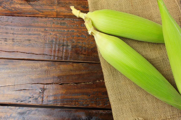 ham Mısır çiftliğinde rustik ahşap masa üzerinde rustik bez üzerinden hasat, kulak. metin için yer