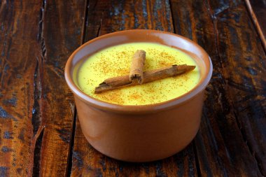 CURAU, Mısır tatlı ve tarçın ile Brezilya mutfağının tipik tatlı krema ahşap masa üzerinde seramik kase yerleştirilir. Uzay kopyalayın. Yakın çekim